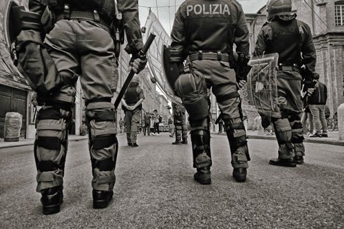 Free Black and white image of police officers with tactical gear during street patrol in an urban setting. Stock Photo