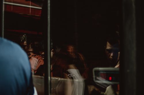 Free Dark and moody reflections of people seen through a glass window, creating an enigmatic atmosphere. Stock Photo