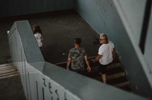 Free People descending a concrete urban staircase, captured from above in a moody tone. Stock Photo