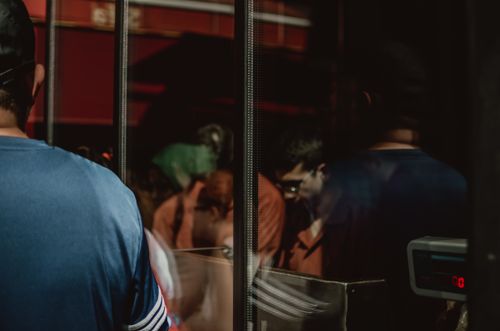 Free People reflected in glass inside a dimly lit room, creating a mysterious atmosphere. Stock Photo