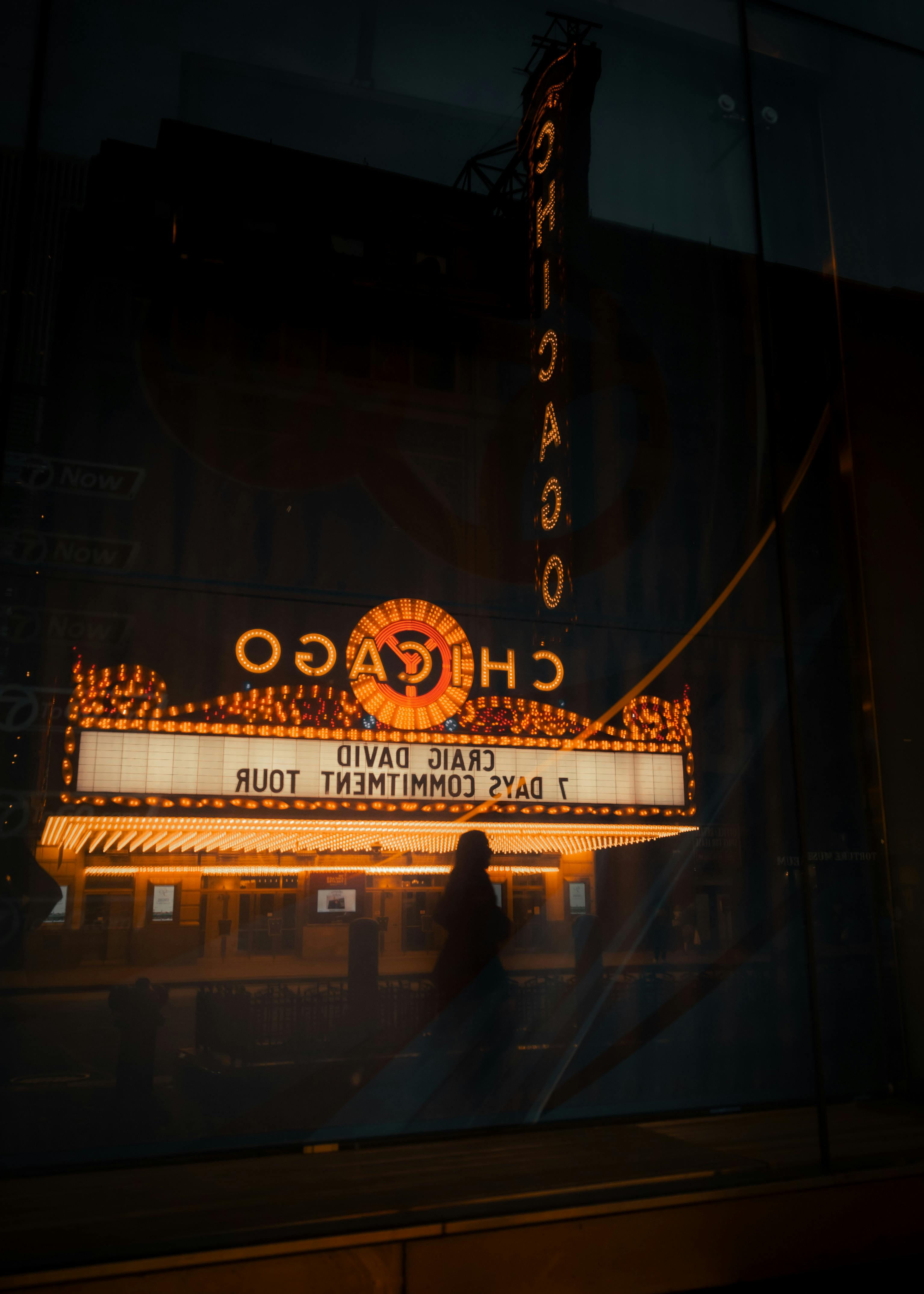 a person is silhouetted in front of the chicago theater