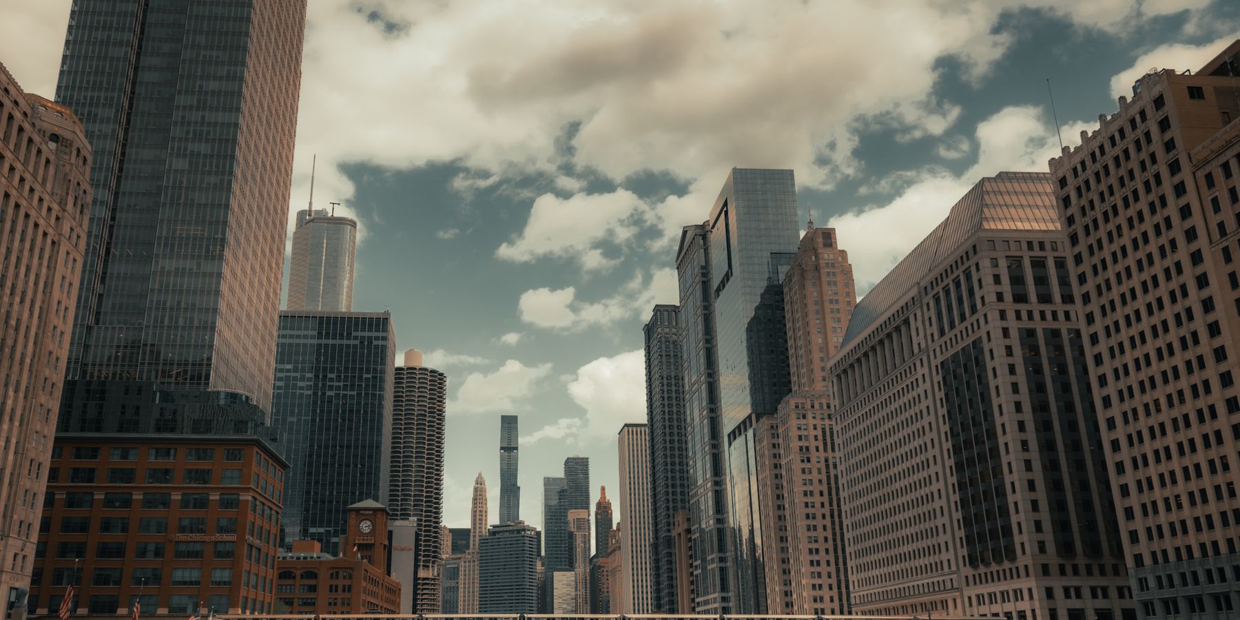 A stunning view of Chicago's skyline and river with prominent skyscrapers and bridges on a cloudy day.