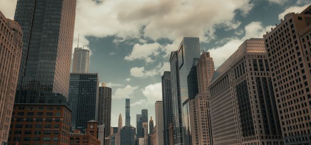 A stunning view of Chicago's skyline and river with prominent skyscrapers and bridges on a cloudy day.