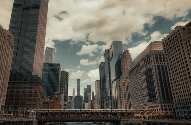 A stunning view of Chicago's skyline and river with prominent skyscrapers and bridges on a cloudy day. — arriving in Chicago