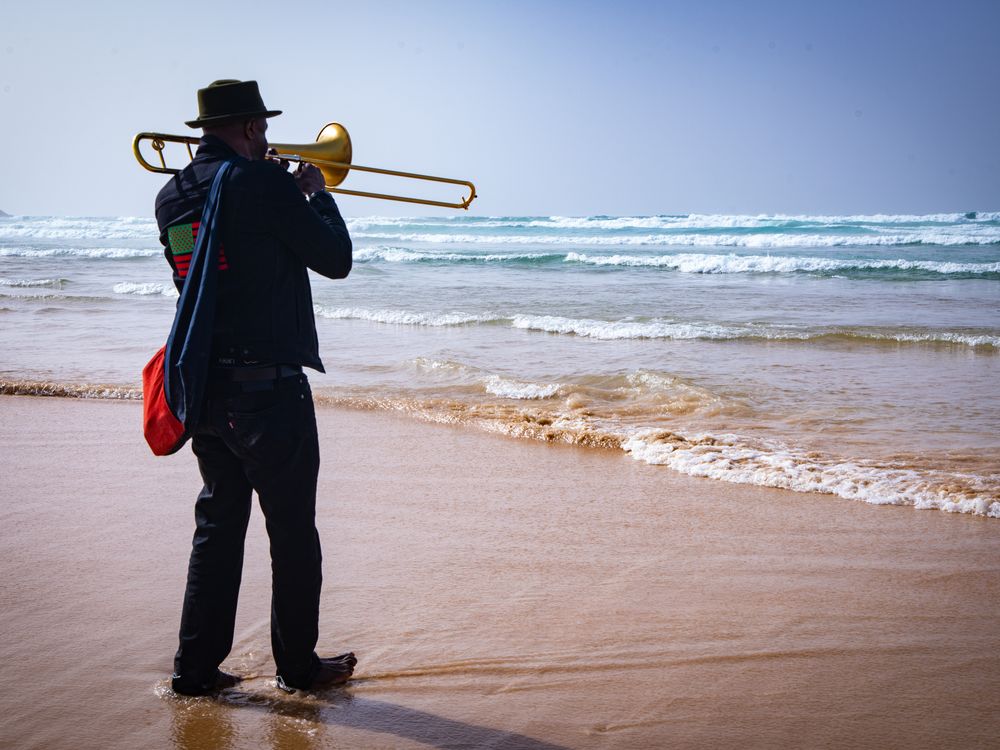 A man playing a trumpet on the beach, Senegal