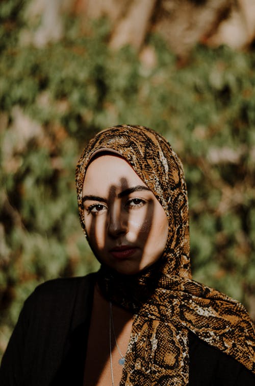 Женщина в коричневом хиджабе из змеиной кожи