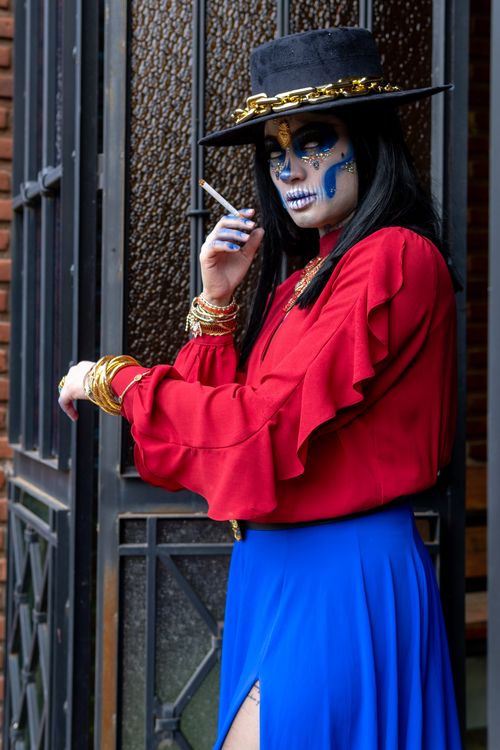 Free Stylish woman in Catrina costume and artistic makeup posing outdoors in Mexico City. Stock Photo