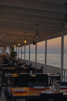 Tranquil beachside restaurant with ocean views at sunset in Vlora, Albania. Perfect for summer dining.