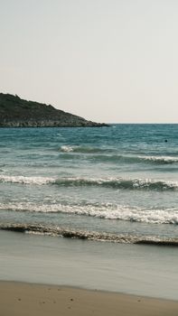 A tranquil beach scene featuring gentle waves and a distant hill, perfect for relaxation.