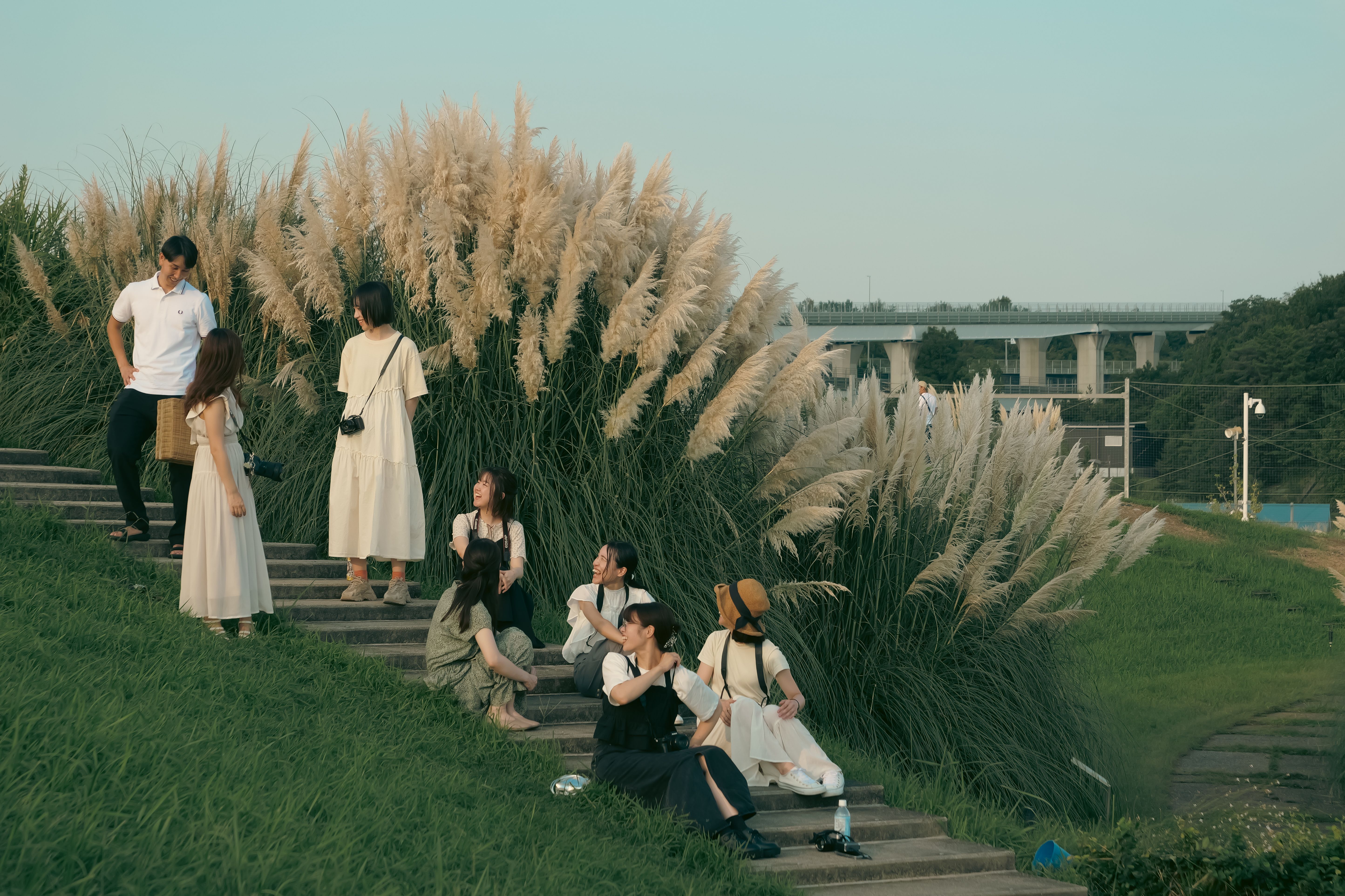 A group of teenagers relaxing on the steps at Ghibli Park in Nagoya, capturing a summer moment.