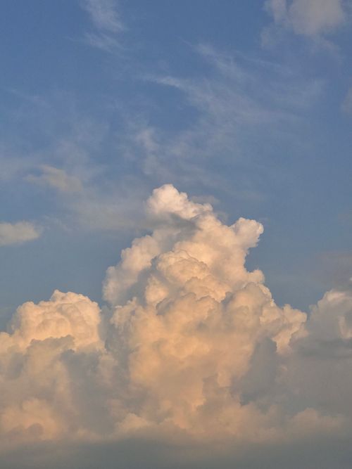 Free A towering cumulus cloud rises against a serene blue sky, capturing the essence of summer weather. Stock Photo