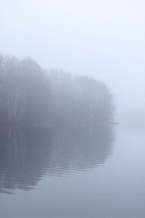 Free A tranquil foggy lake scene captured in winter, emphasizing calm and reflection. Stock Photo