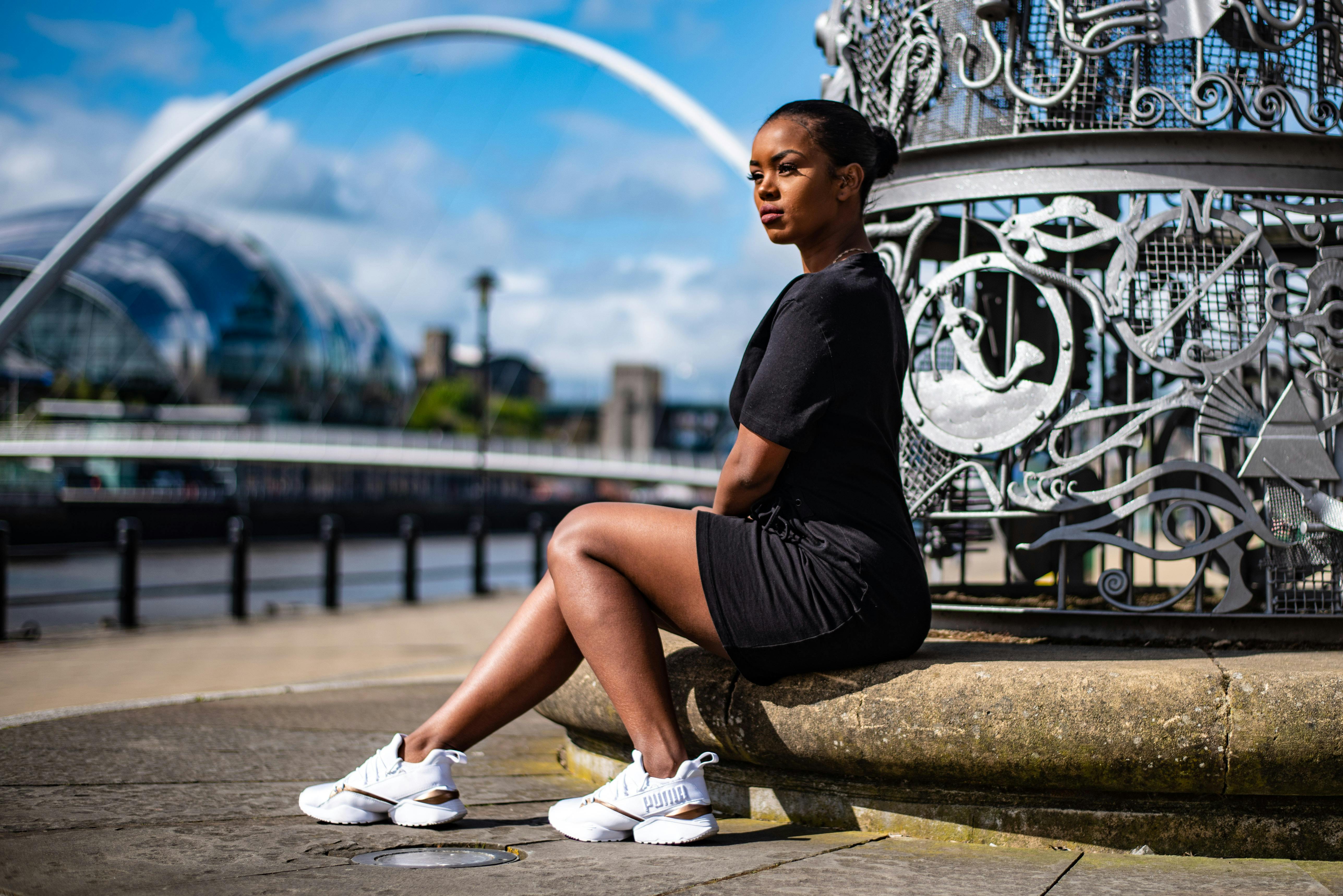 a woman sitting on a bench in front of a clock