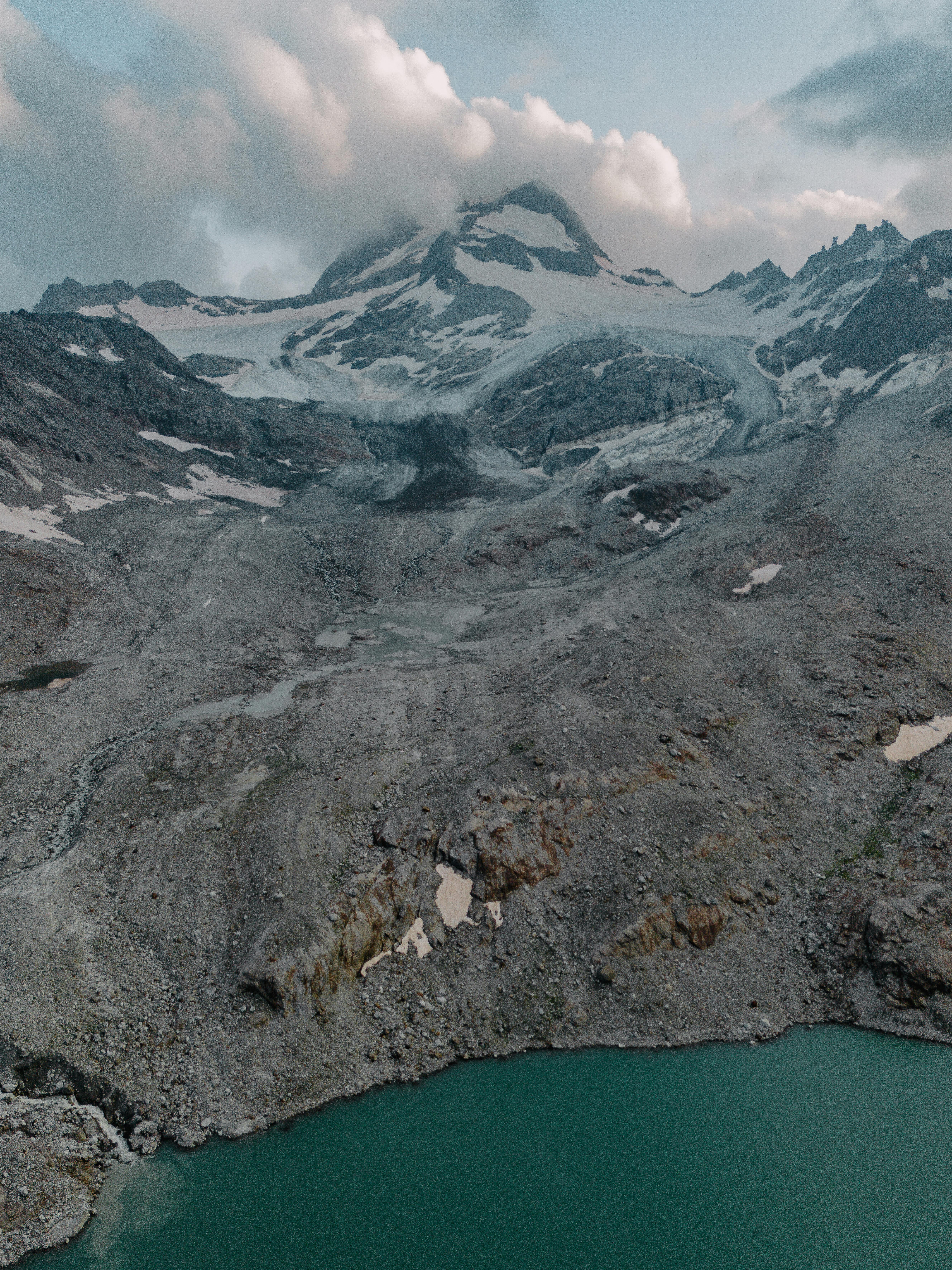 A breathtaking view of a mountain and glacier above a pristine alpine lake.