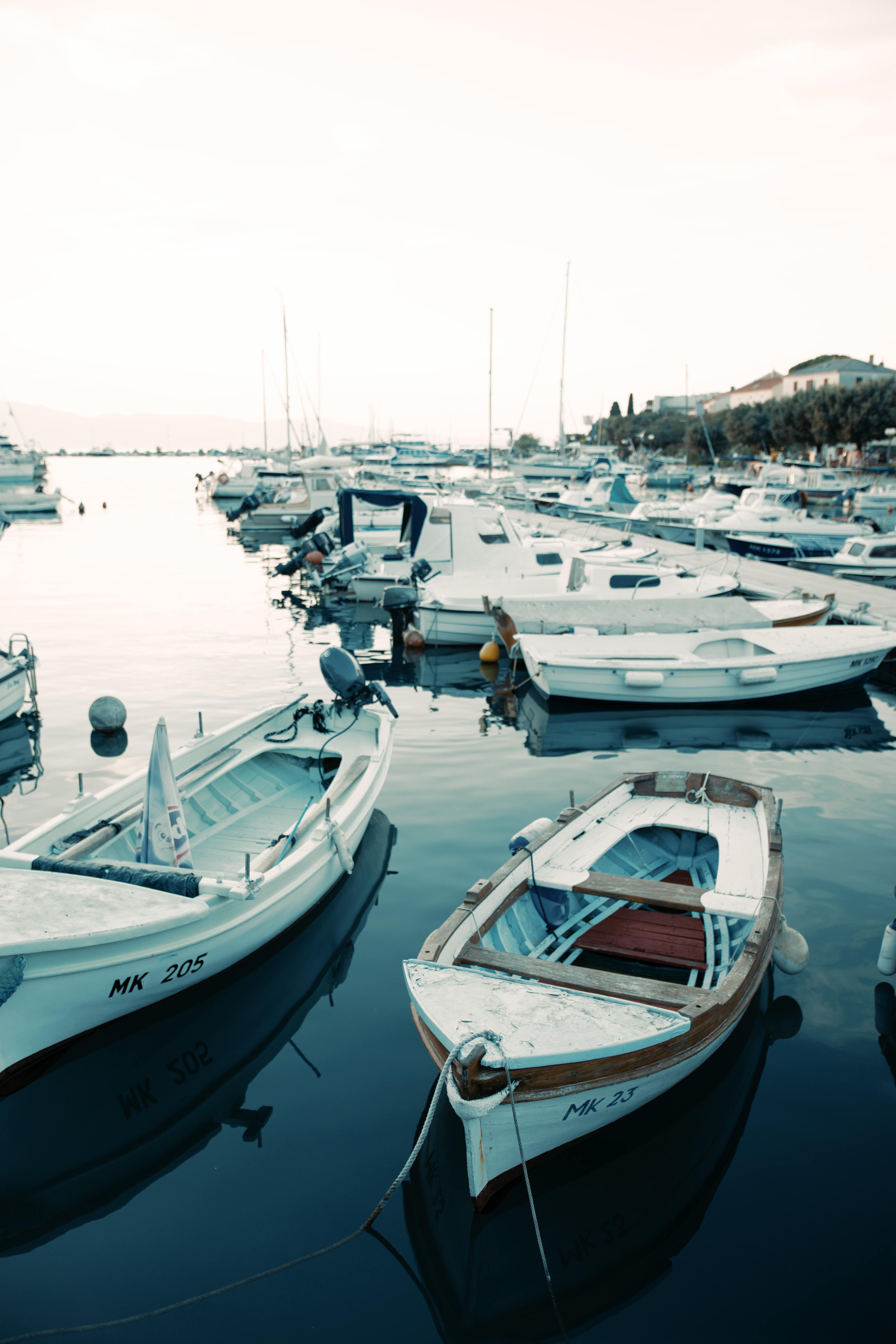 A tranquil harbor scene with moored fishing boats and yachts at sunrise, perfect for travel imagery.