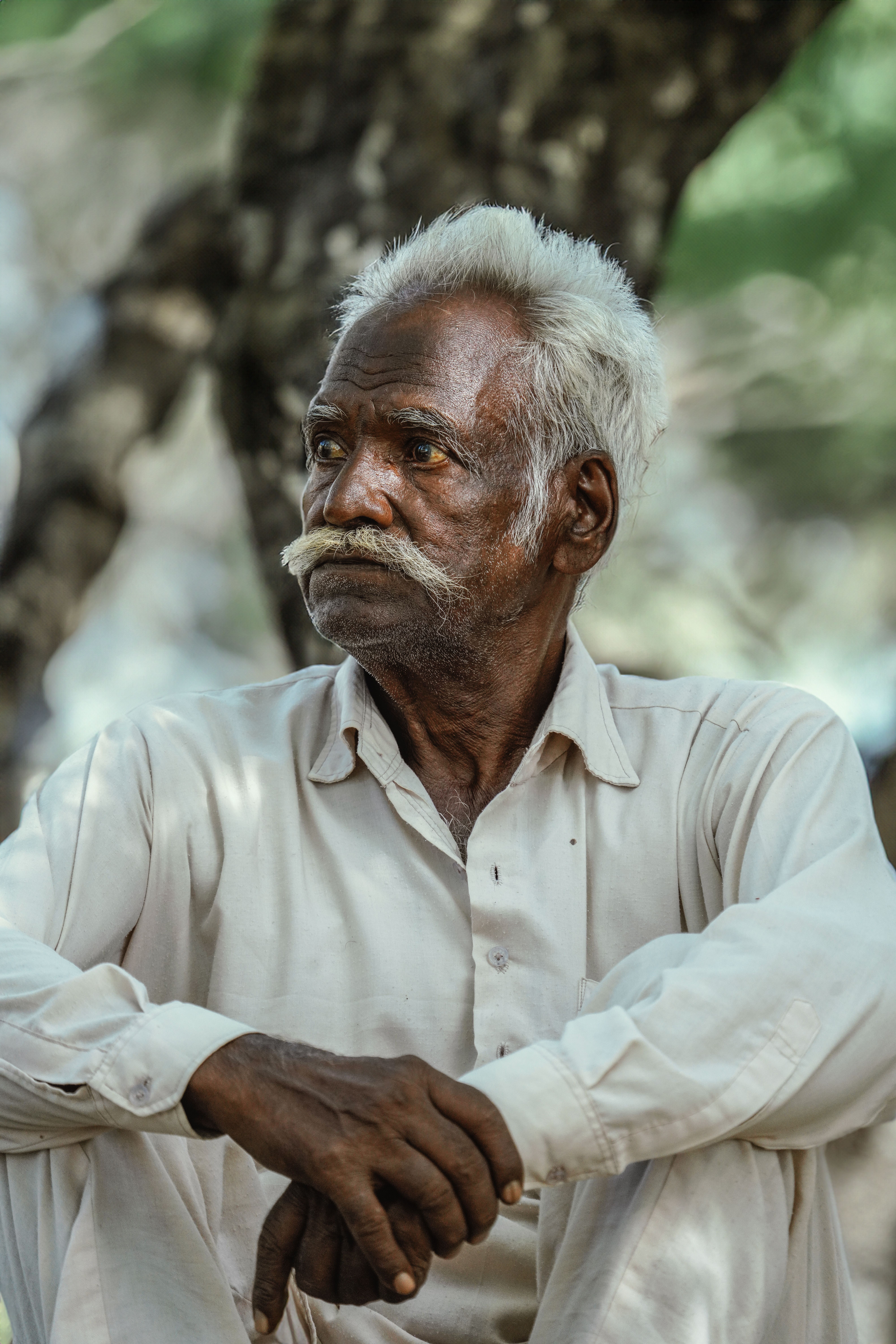 Made Wirawan, founder and Balinese healing elder of Suvarna Wellness, seated among the pavilion gardens