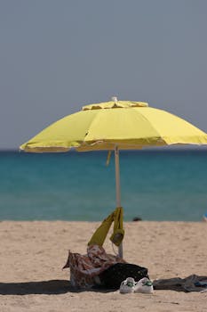 Relaxing scene of a yellow umbrella on Poetto Beach, Sardinia, Italy.