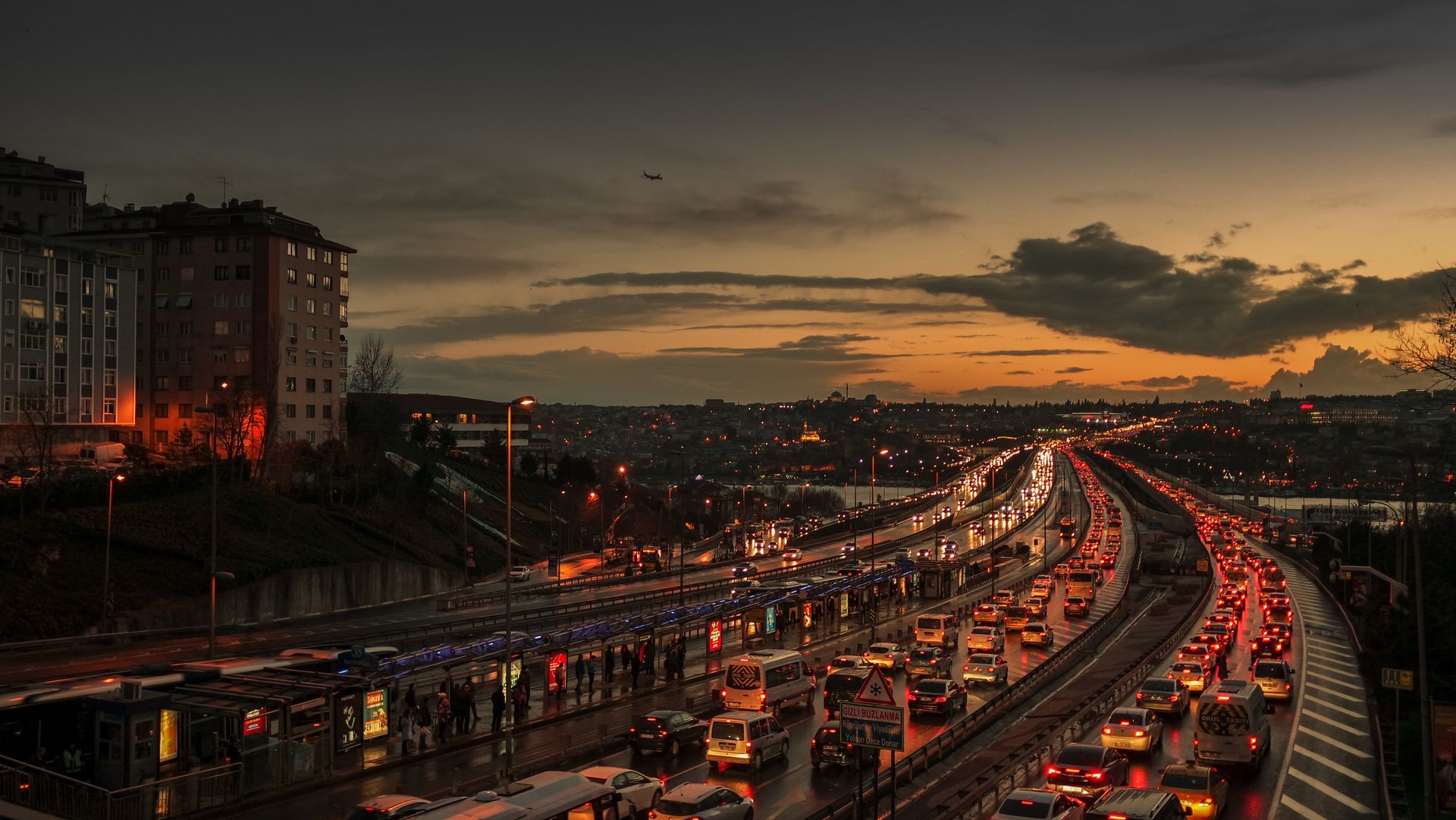 Heavy traffic flows on a city highway during dusk, capturing urban evening life.