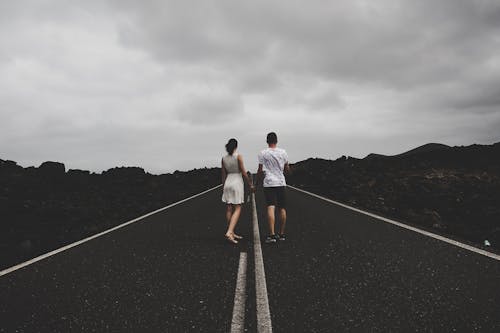 Free Photo Of Couple Holding Hands On The Road Stock Photo