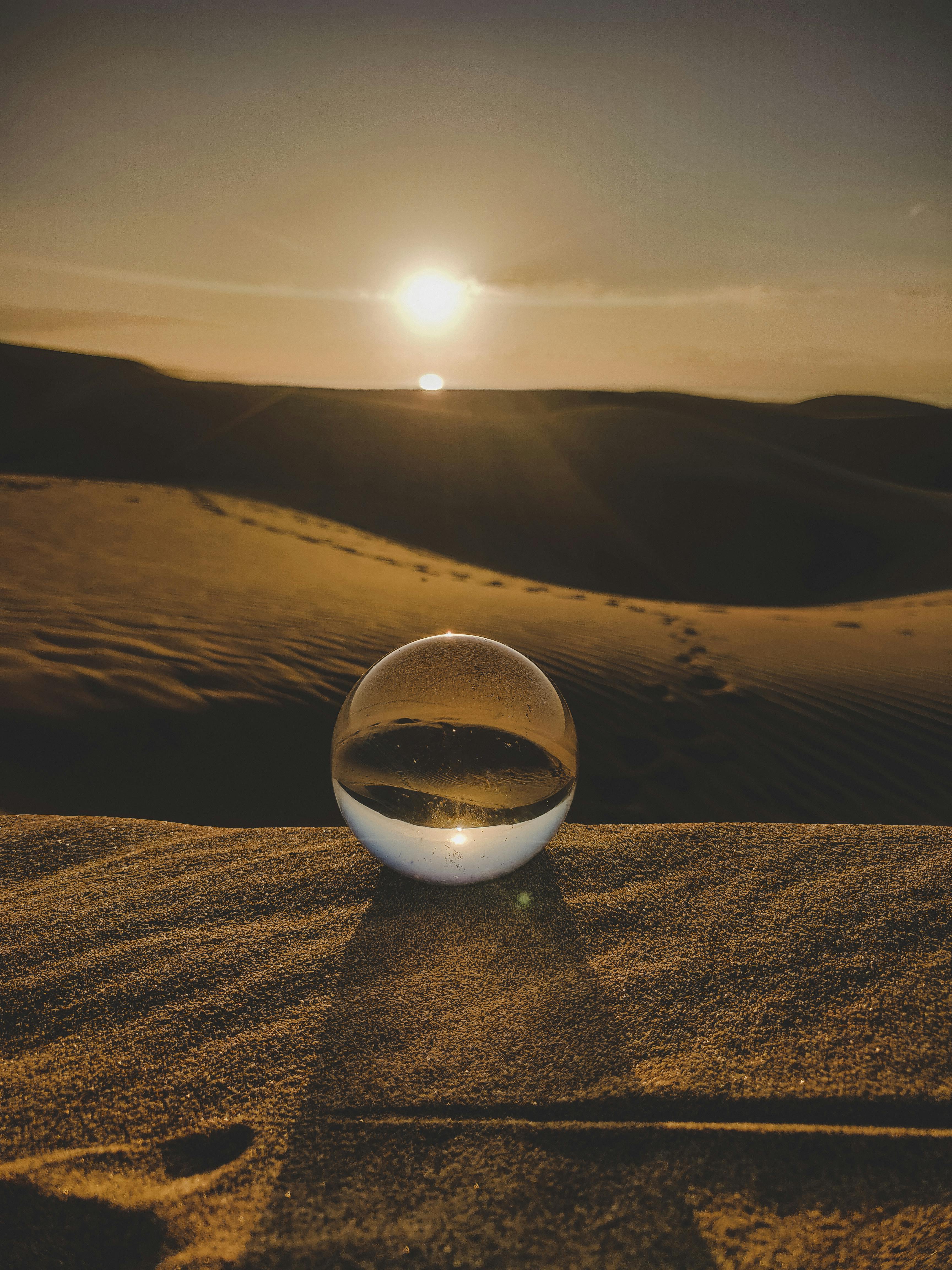 clear ball on brown sand dunes