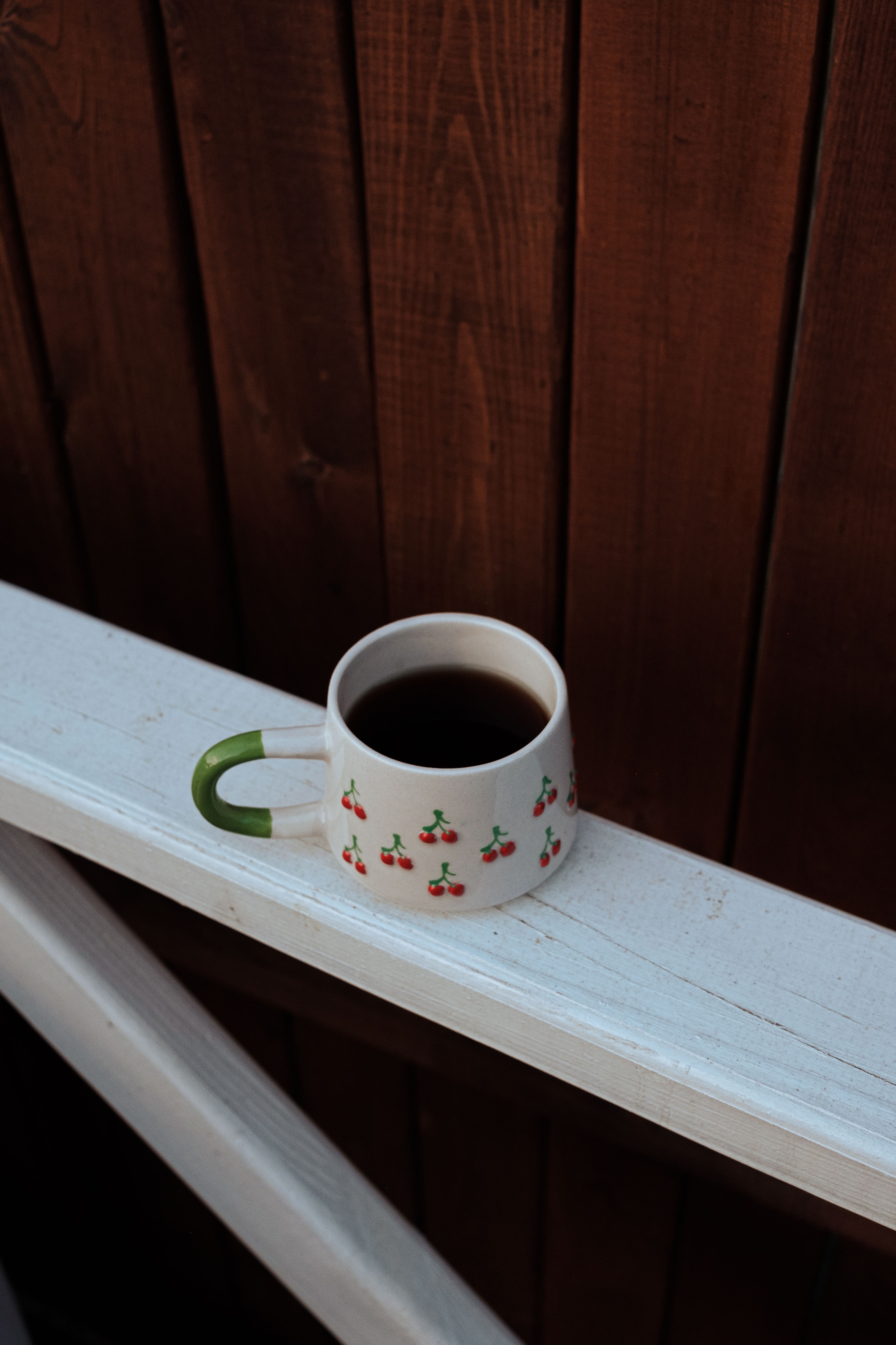 A cup of coffee on a railing · Free Stock Photo