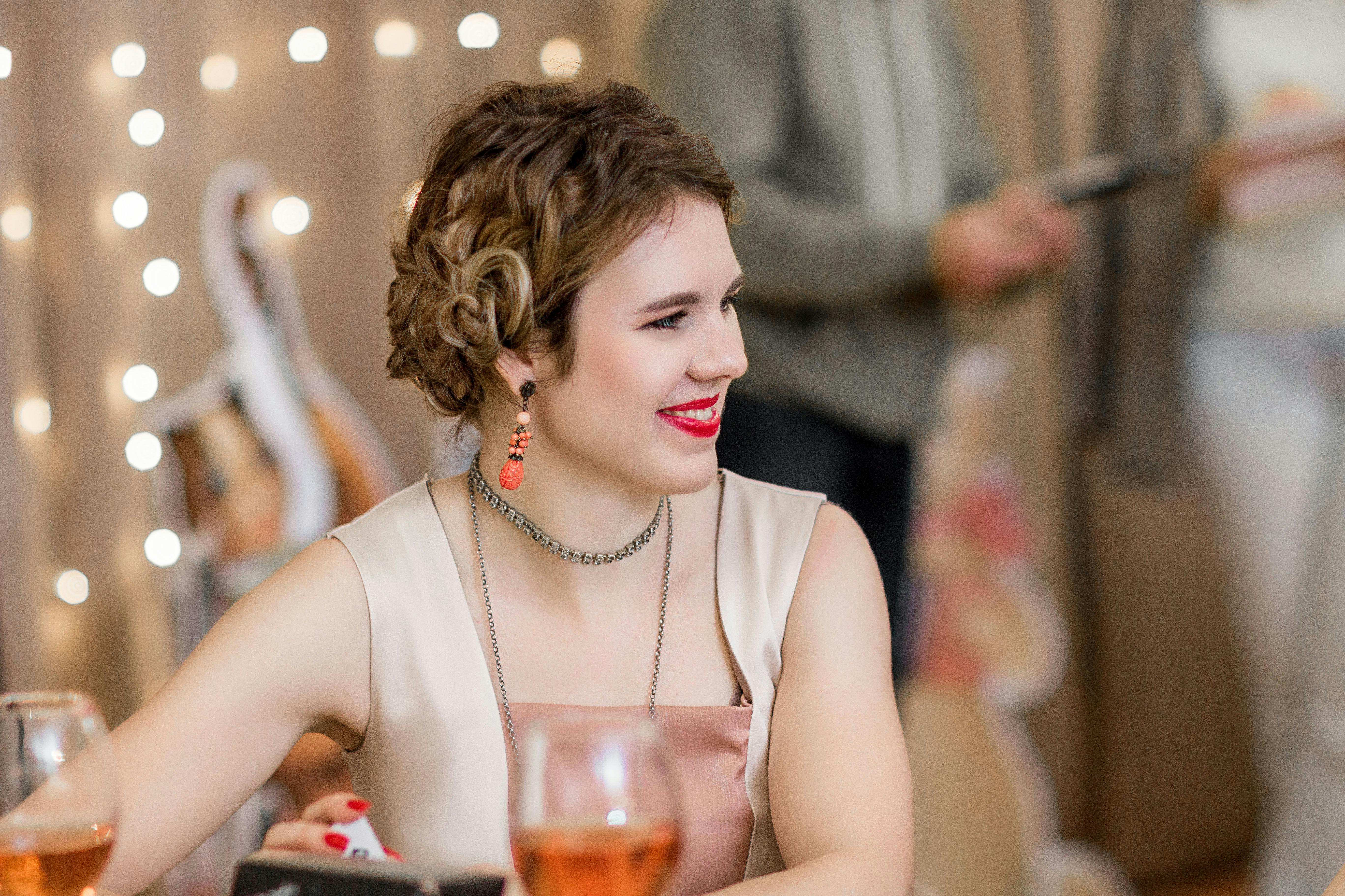 a woman sitting at a table with a glass of wine