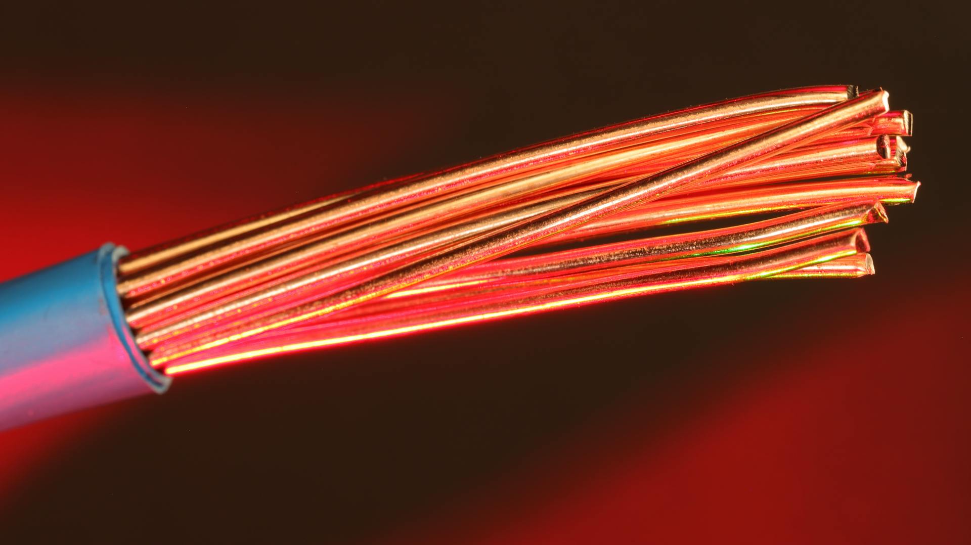 Detailed image of copper wires illuminated by red light, highlighting texture and color.