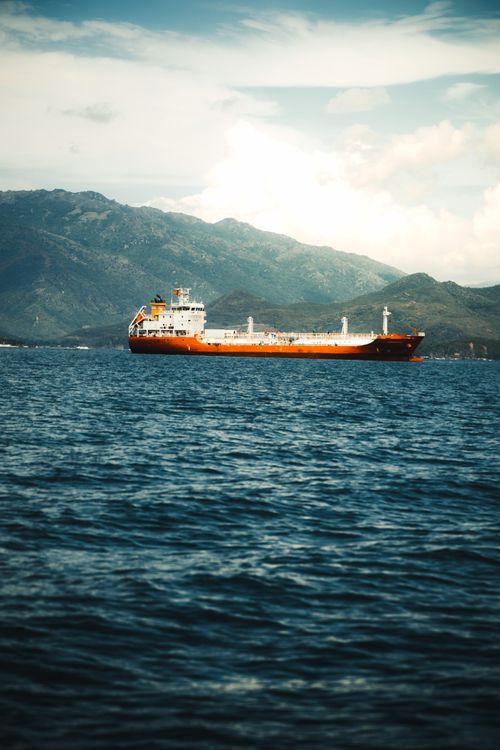 Free A cargo ship sails on the calm waters of Nha Trang Bay with mountains in the background. Stock Photo