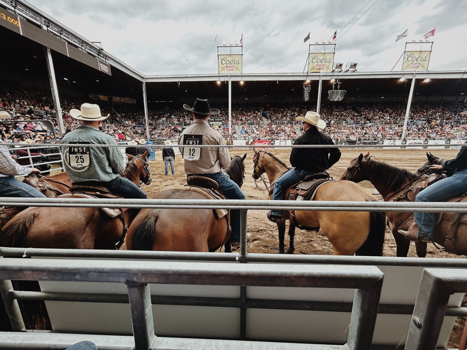 Público e competidores em arena de rodeio