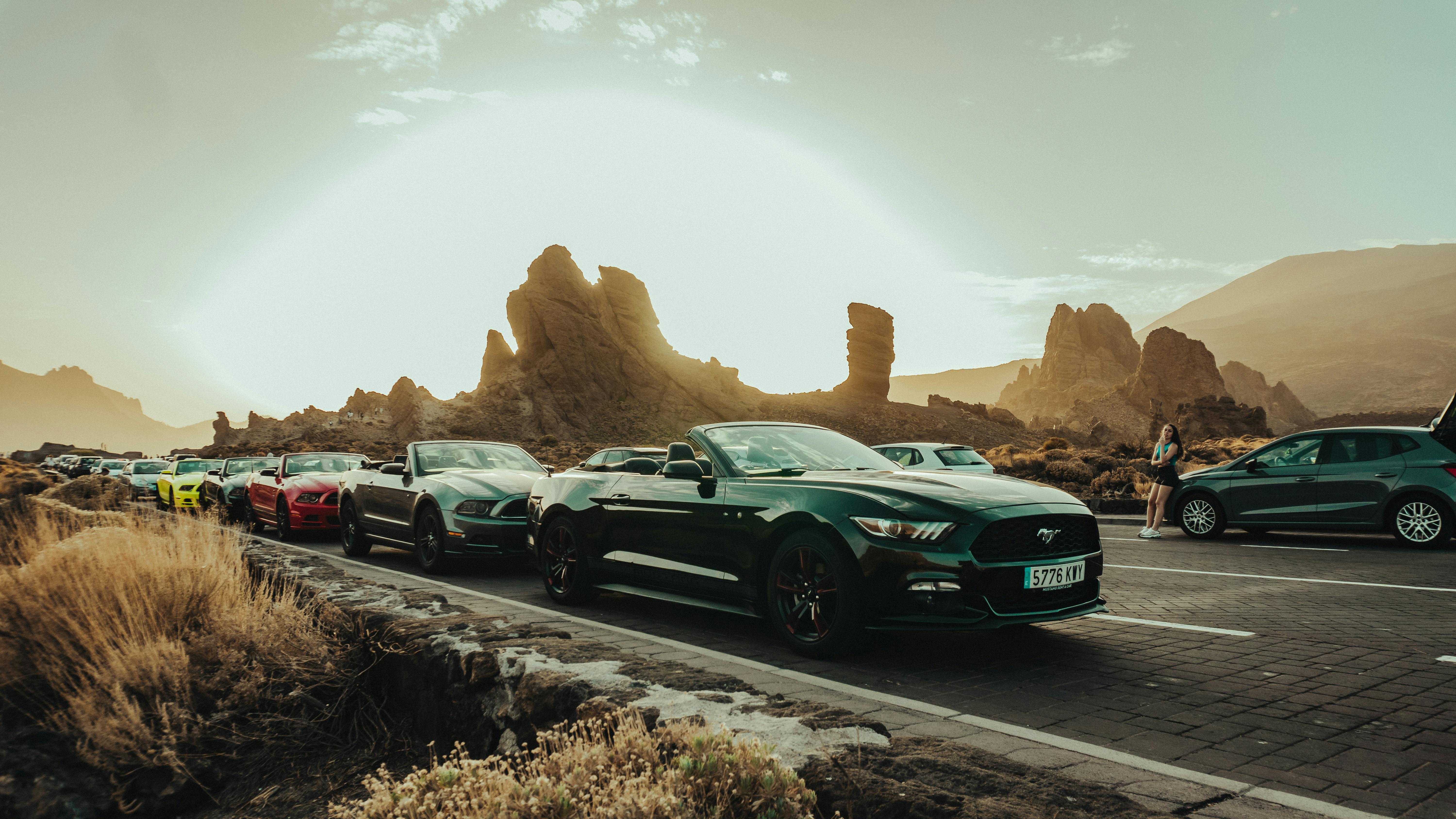 cars driving on a road with mountains in the background