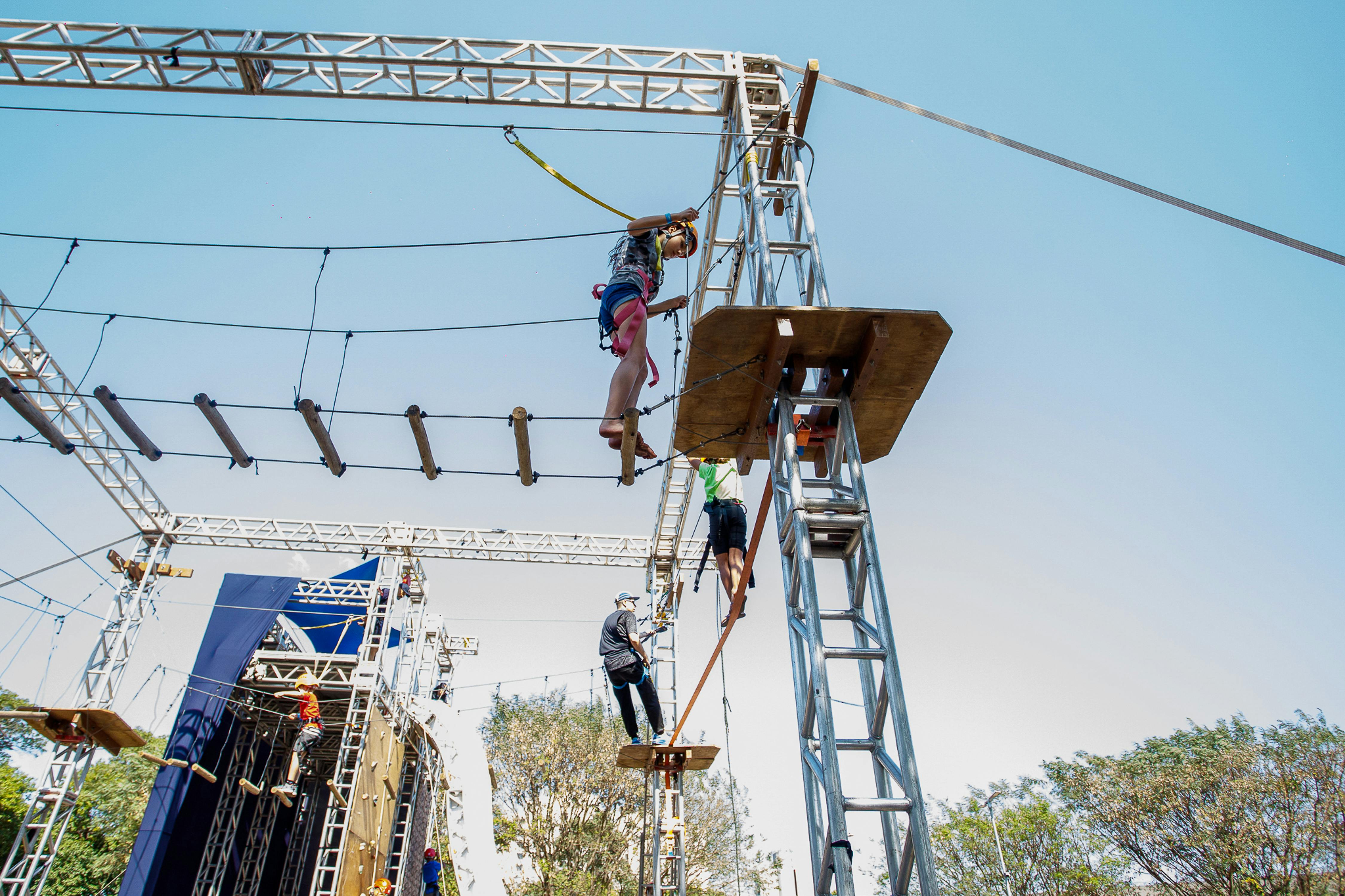 People climbing a high ropes course outdoors, enjoying adventure and teamwork