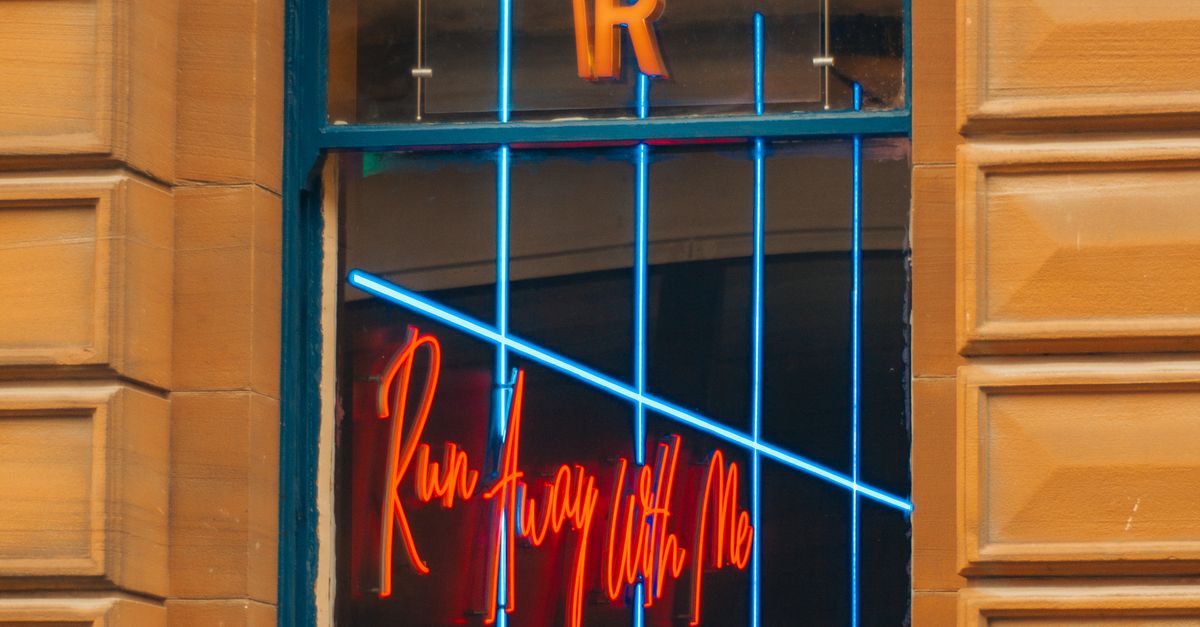 Neon Sign Window Frame A Red Neon Sign Hanging in the Window · Free Stock Photo