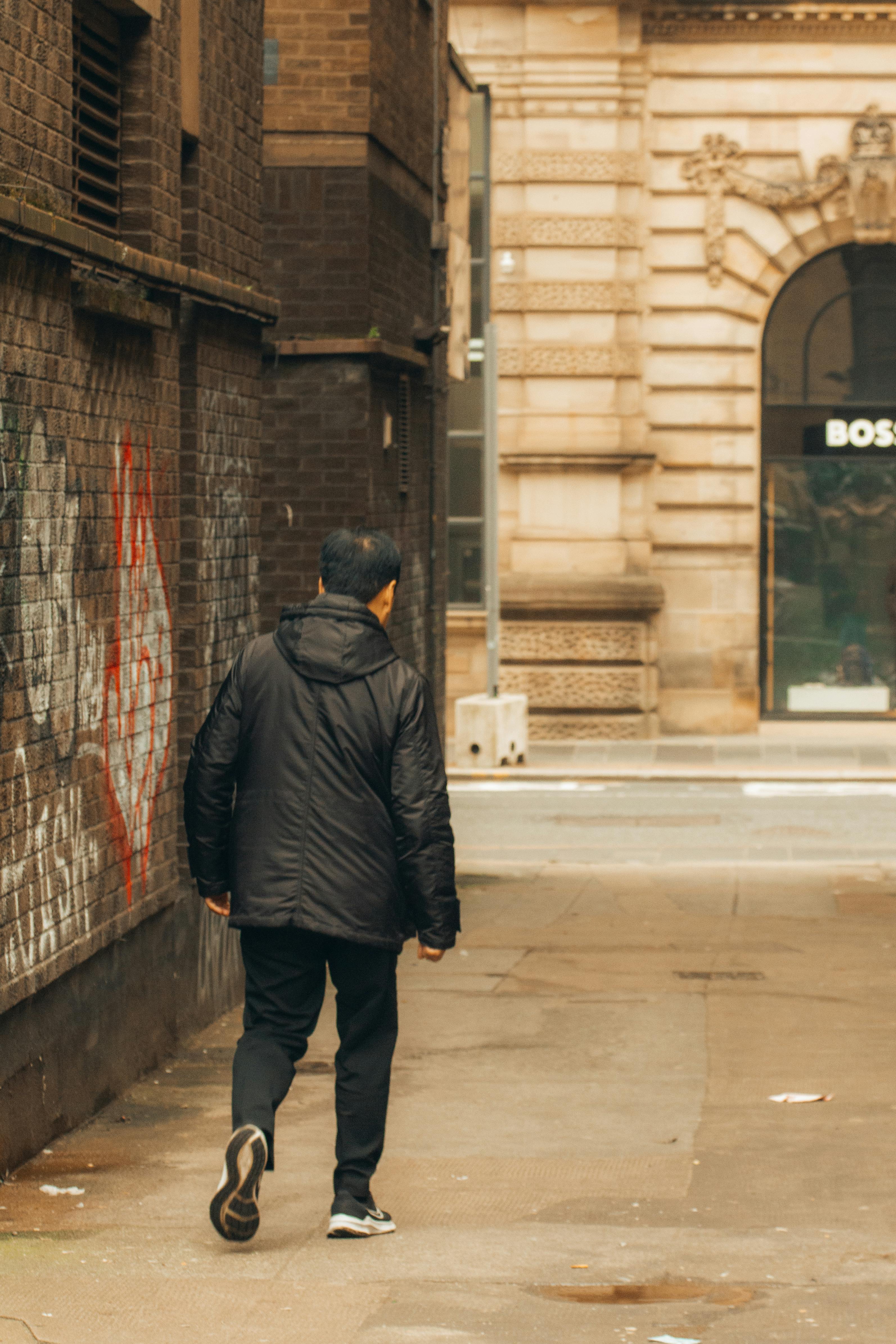 a man walking down a narrow alleyway