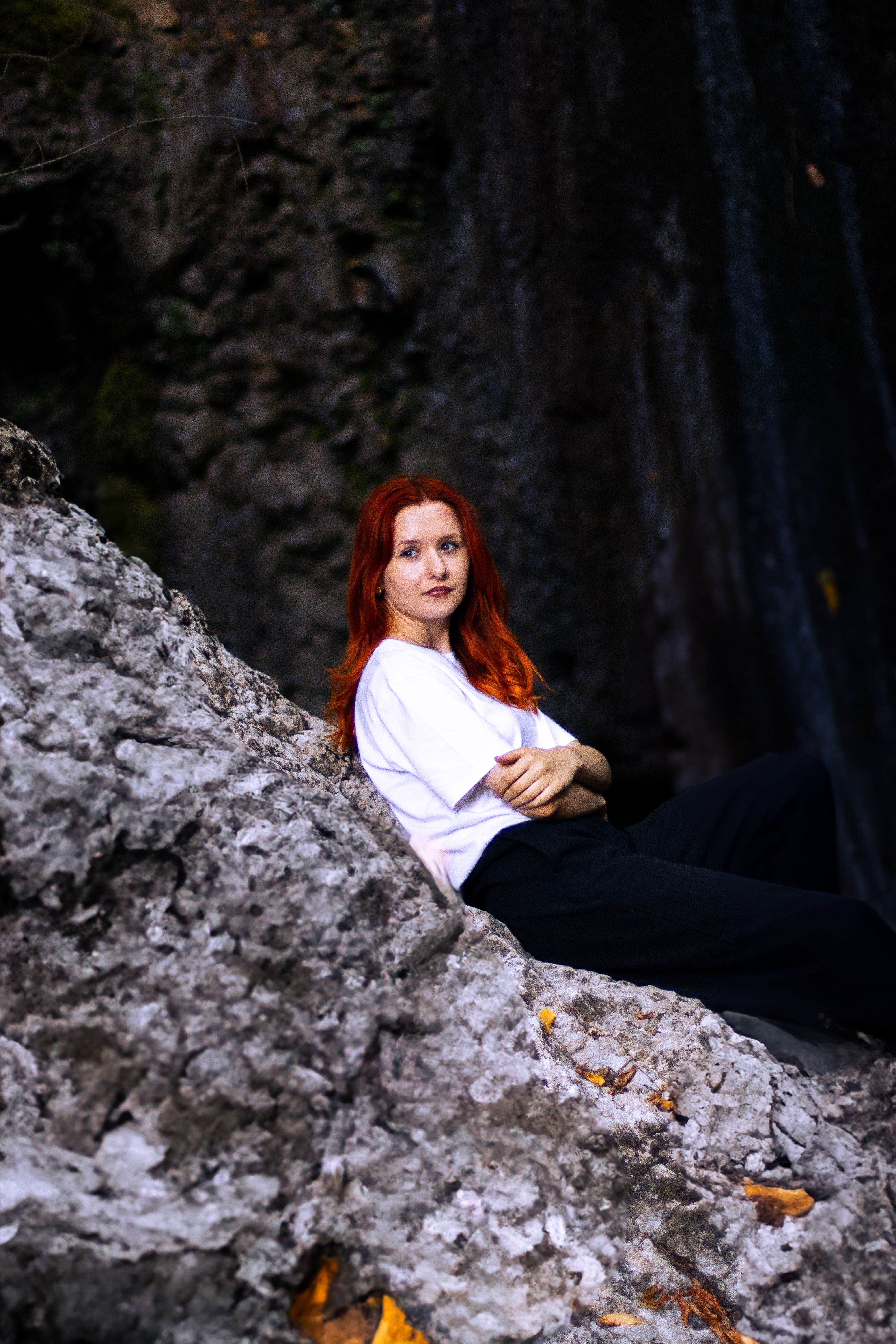 A woman with red hair sitting on a rock · Free Stock Photo