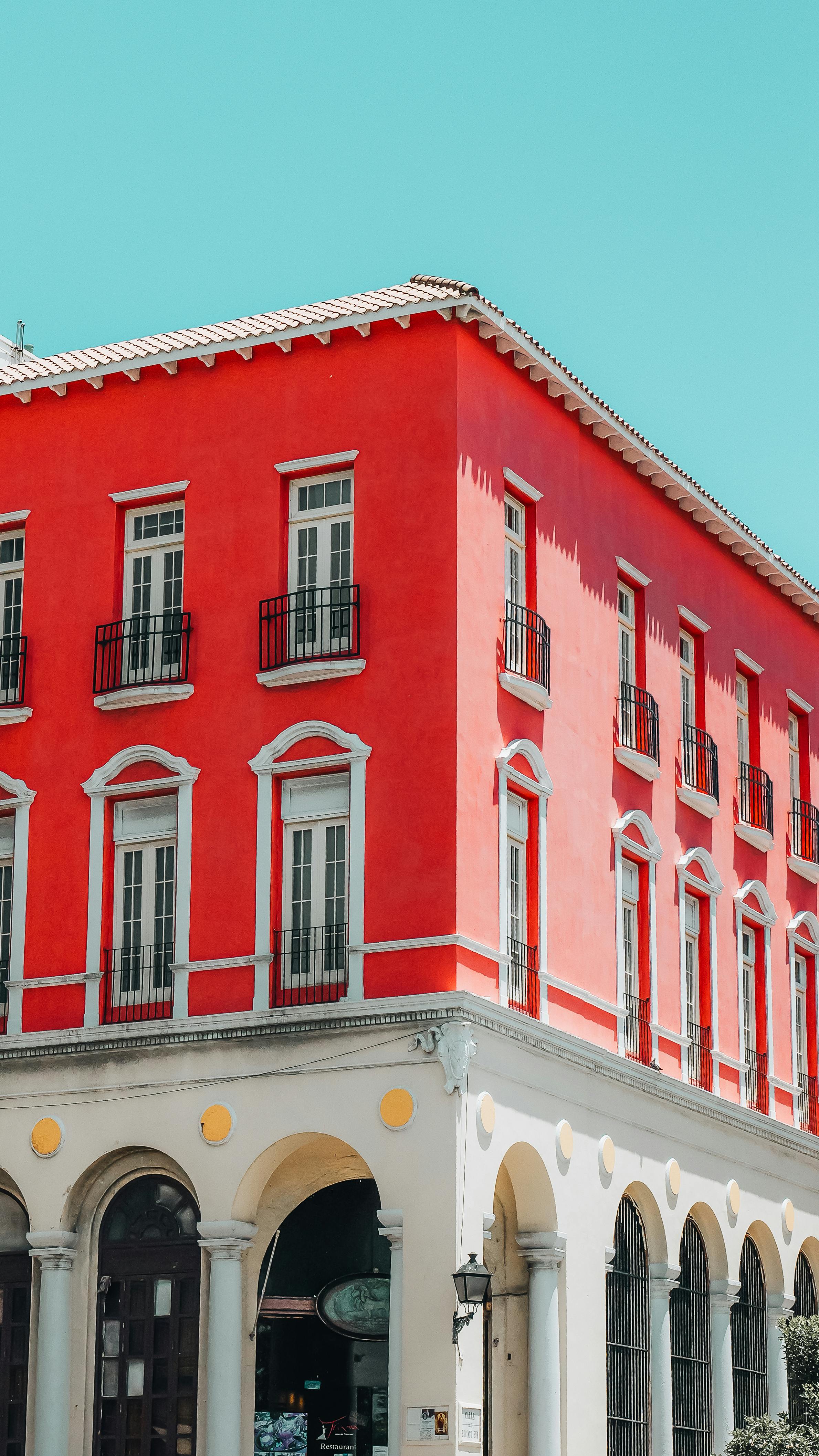 a red building with a white roof and a blue sky