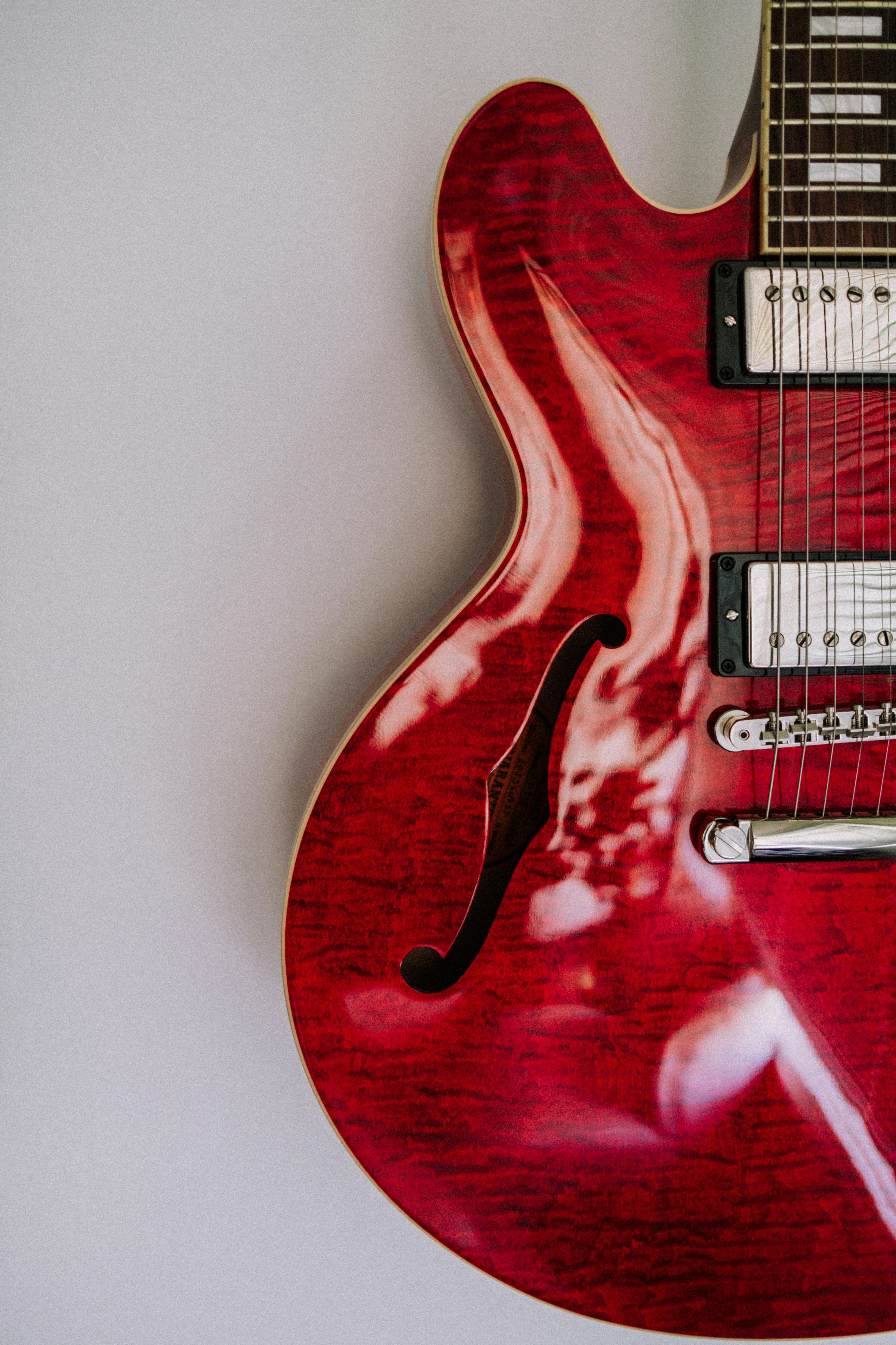 Close-up view of a red electric guitar showcasing its intricate design and craftsmanship.