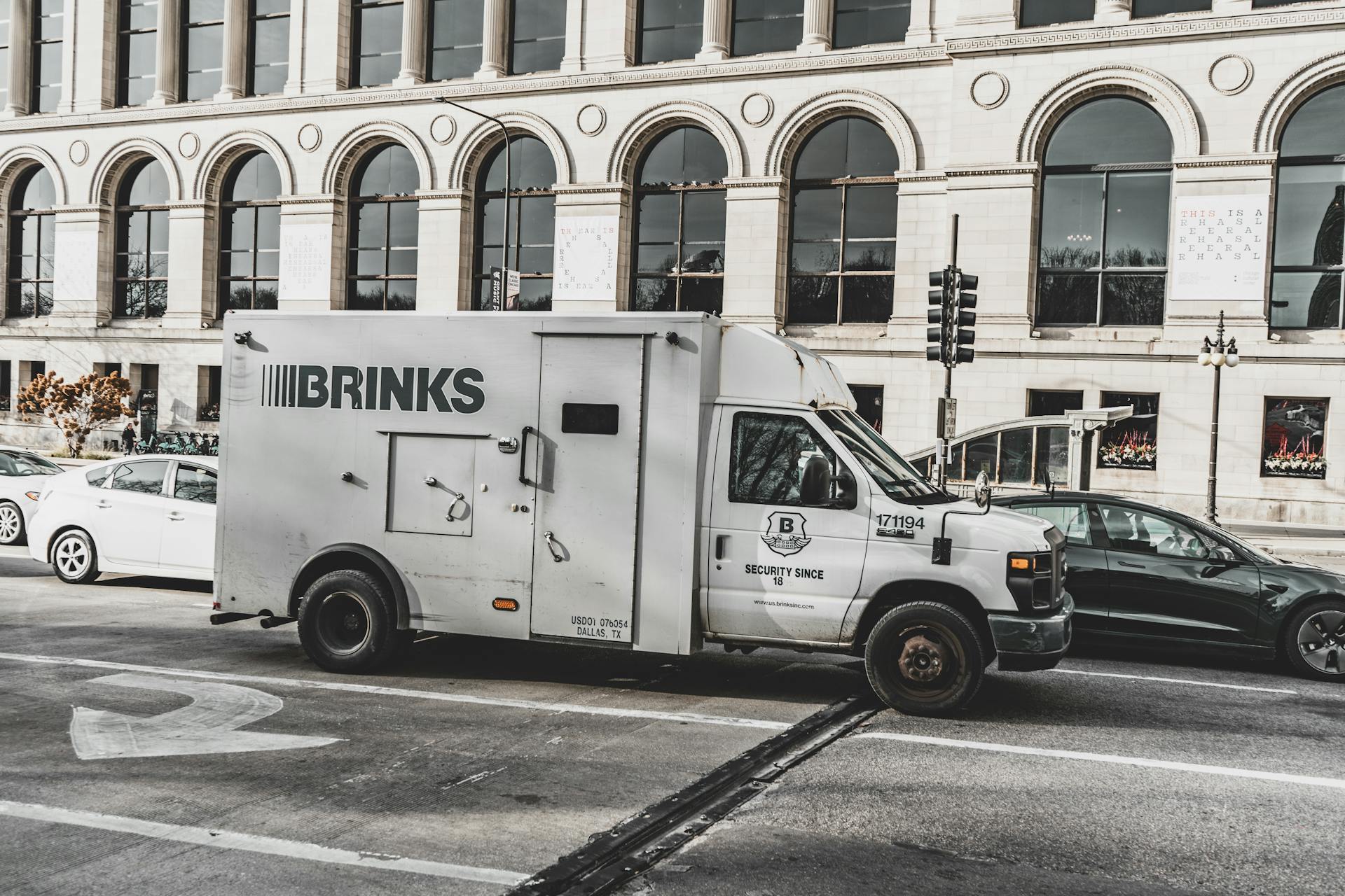 A Brinks armored security truck parked on a busy Chicago street, showcasing urban architecture.