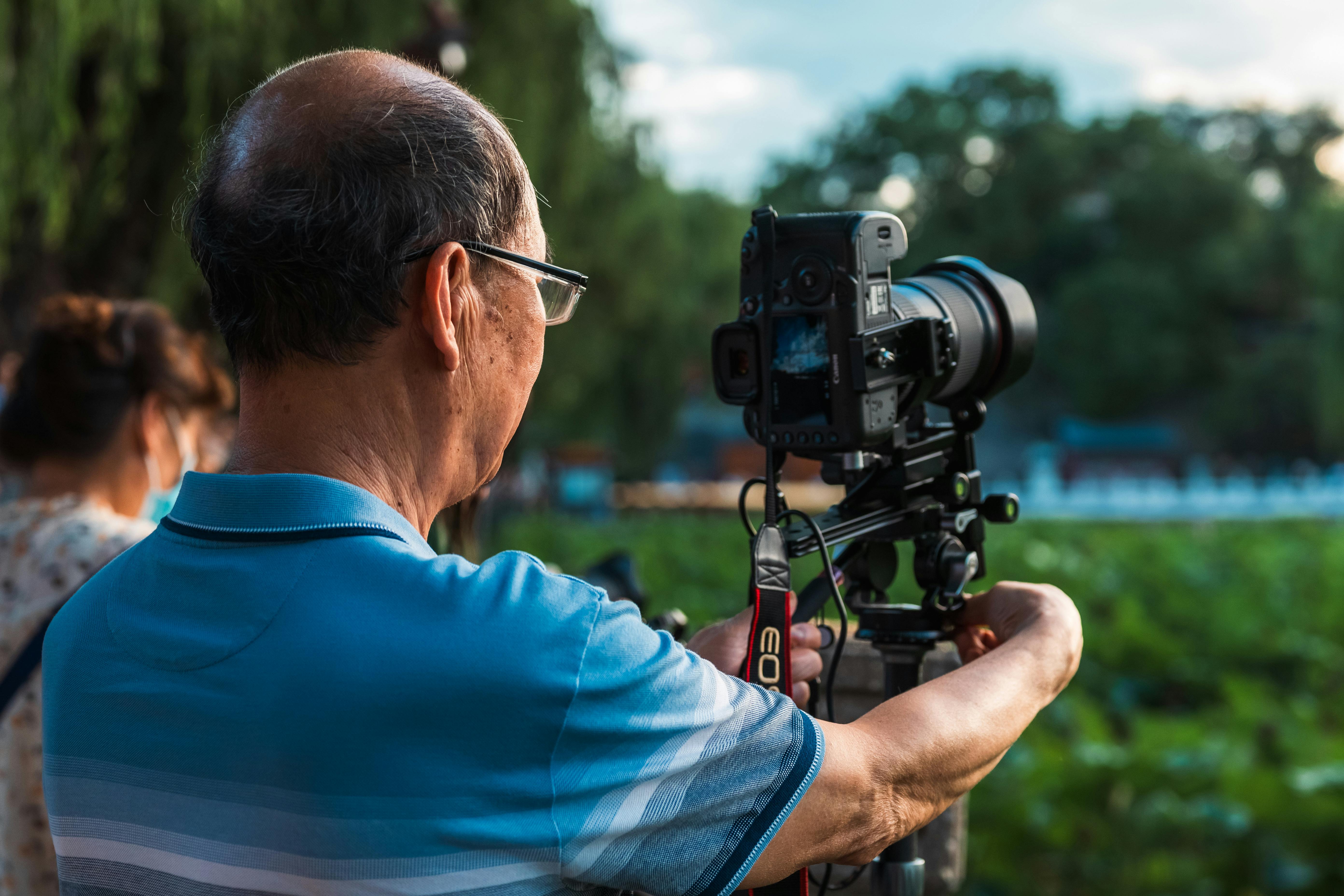 a man holding a camera in front of a group of people