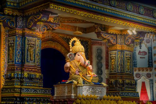 Free A detailed sculpture of Lord Ganesh seated in a vibrant, ornately decorated temple in Pune, India. Stock Photo
