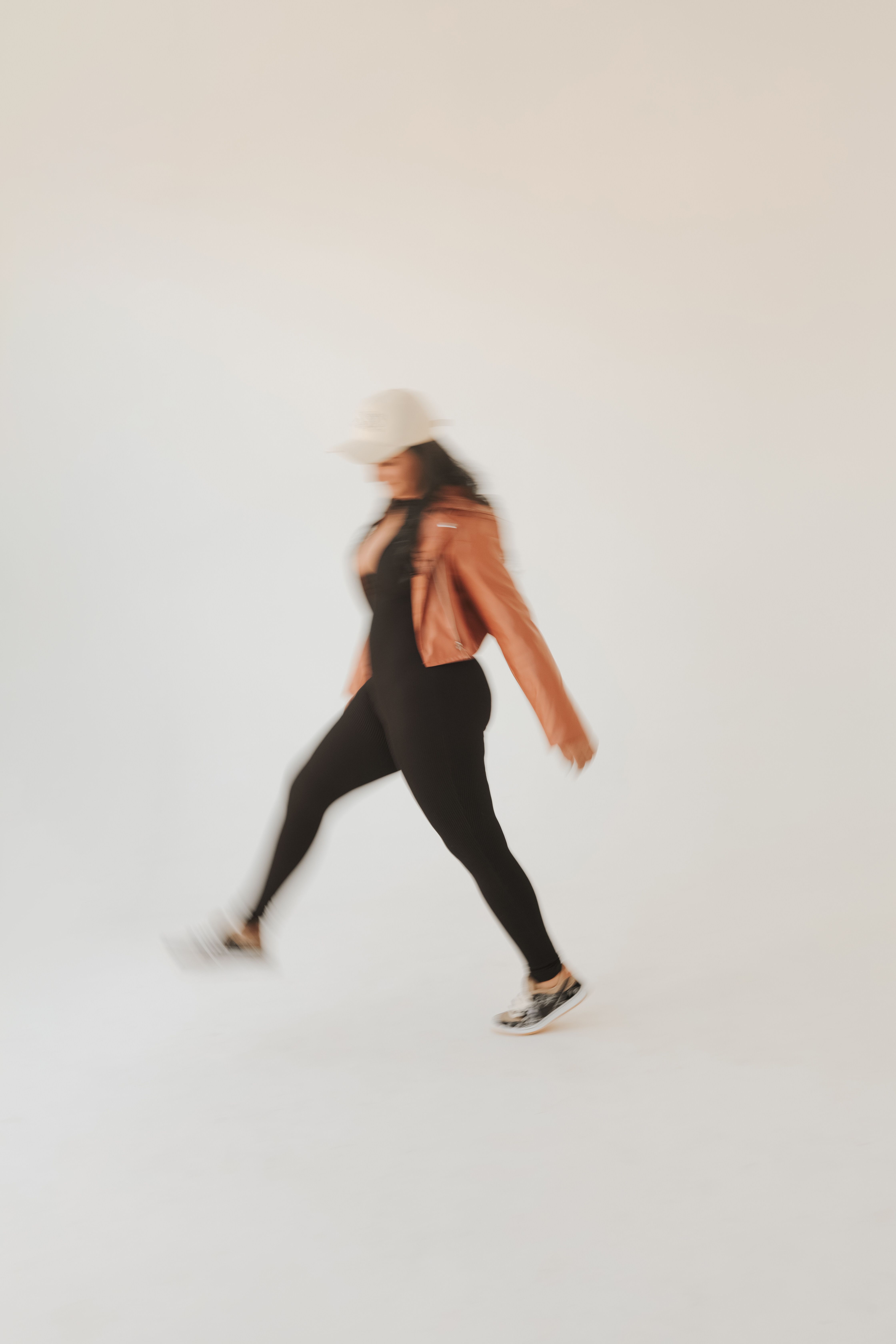 A fashionable woman in motion, blurred effect, showcases dynamic and stylish fashion.