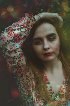 Stylish portrait of a woman in a floral dress with artistic bokeh effects, exuding individuality and elegance.