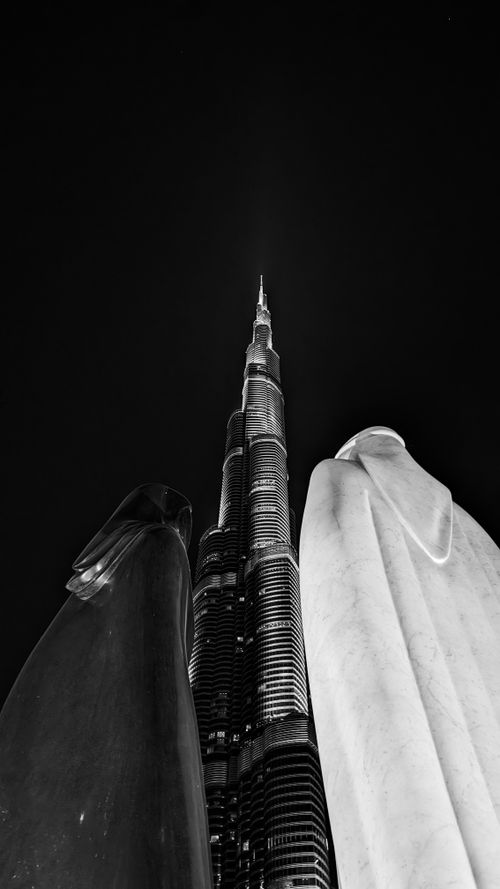 Free Black and white view of Burj Khalifa surrounded by sculptures, showcasing modern architecture. Stock Photo