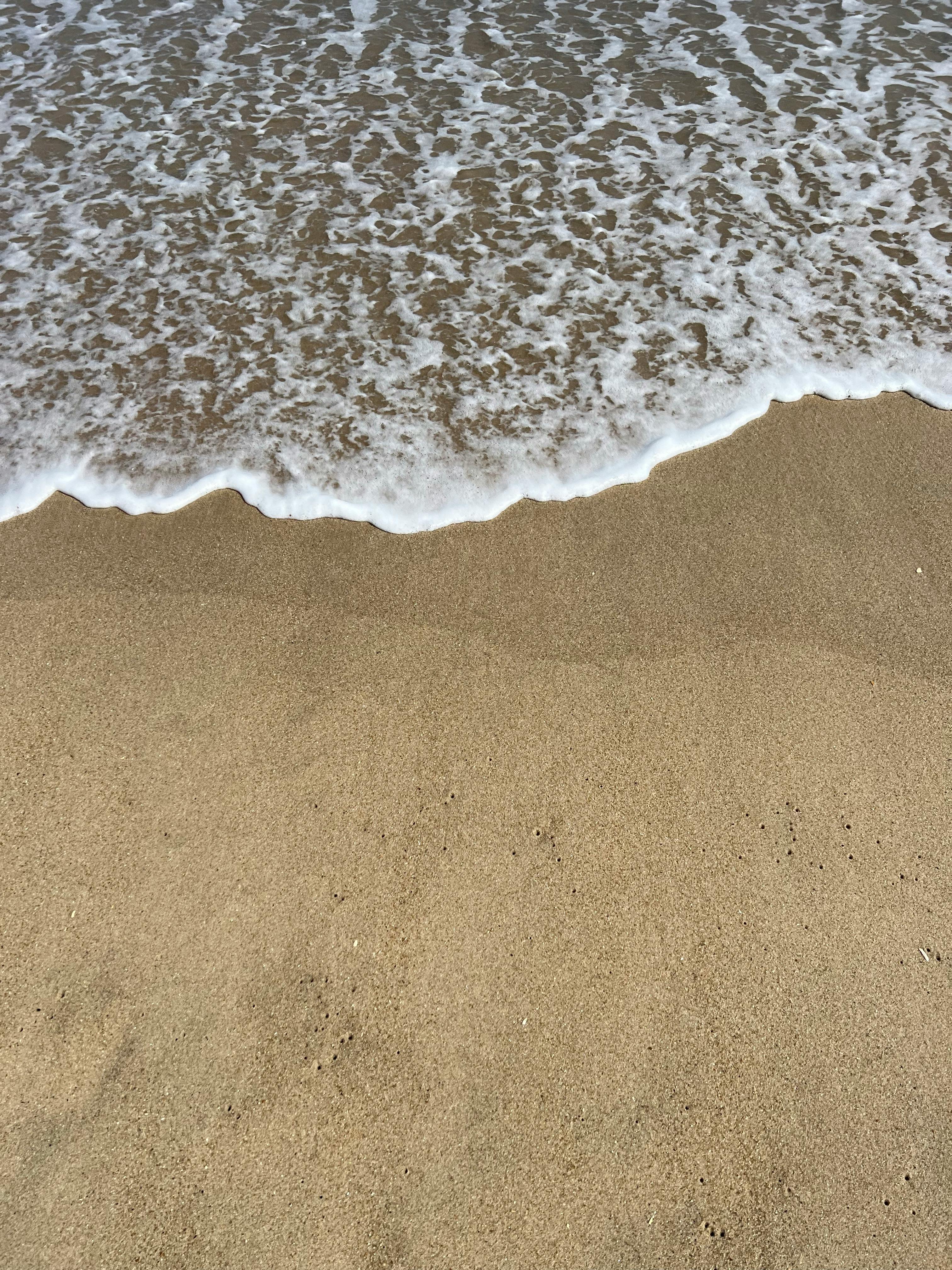 a beach with waves and sand on it