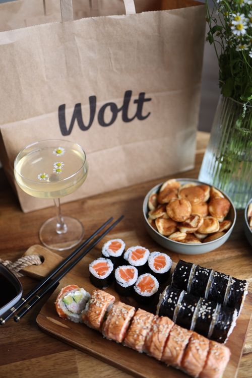Free A sushi platter served with a cocktail, showcasing salmon rolls and a beverage on a rustic wooden table. Stock Photo