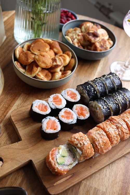 Free A selection of sushi rolls and snacks on a wooden platter, perfect for any meal. Stock Photo