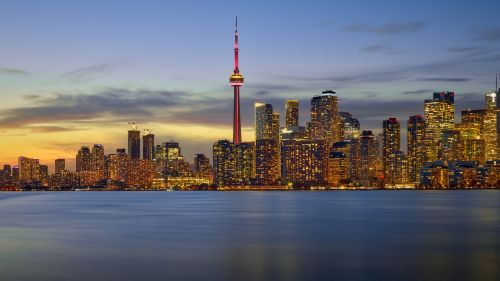 Free Vibrant Toronto skyline with CN Tower at dusk, reflecting over calm waters. Stock Photo