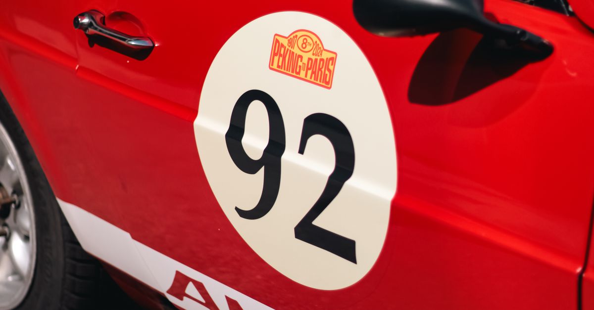 A red and white rally car with the number 92 on it · Free Stock Photo