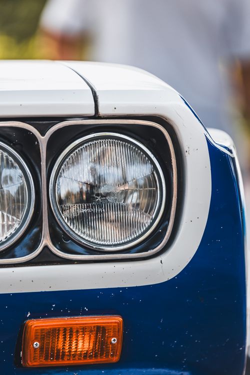 Free Detailed view of a vintage car's headlight and bumper showcasing classic design. Stock Photo