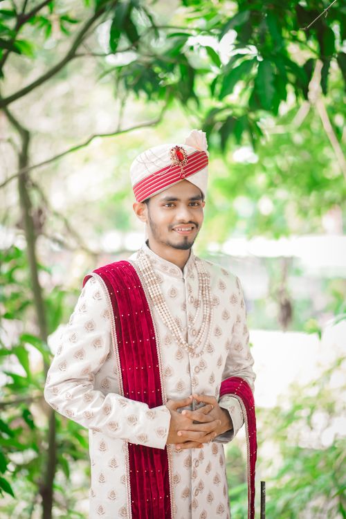 Free Charming Bengali groom in traditional wedding attire poses outdoors with a smile. Stock Photo