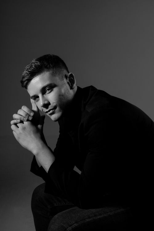 Free Artistic black and white portrait of a man posing thoughtfully in a studio setting. Stock Photo